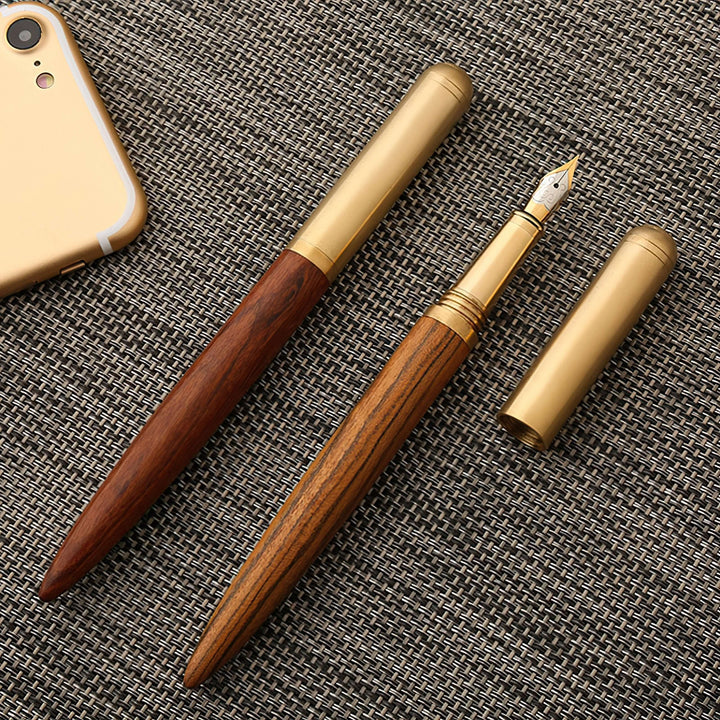 Vintage Wood and Brass Fountain Pen | The Hemmingway displayed on a textured surface, showcasing its elegant wooden and brass design.