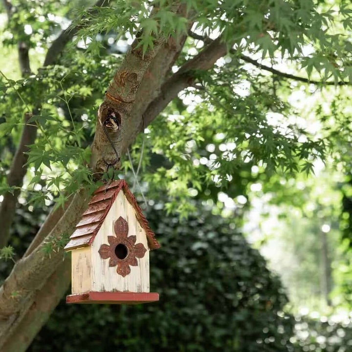 Vintage-Inspired Wooden Birdhouse with Terracotta Roof hanging in a lush garden tree