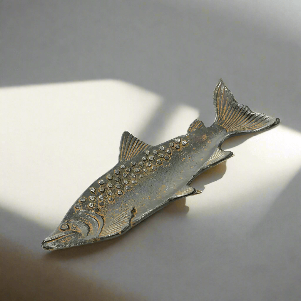 Vintage cast iron fish shaped tray with rustic patina, detailed scales, capturing the charm of a waterfront retreat.