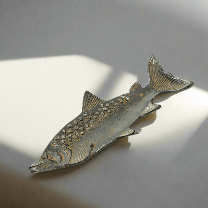 Vintage cast iron fish shaped tray with rustic patina, detailed scales, capturing the charm of a waterfront retreat.
