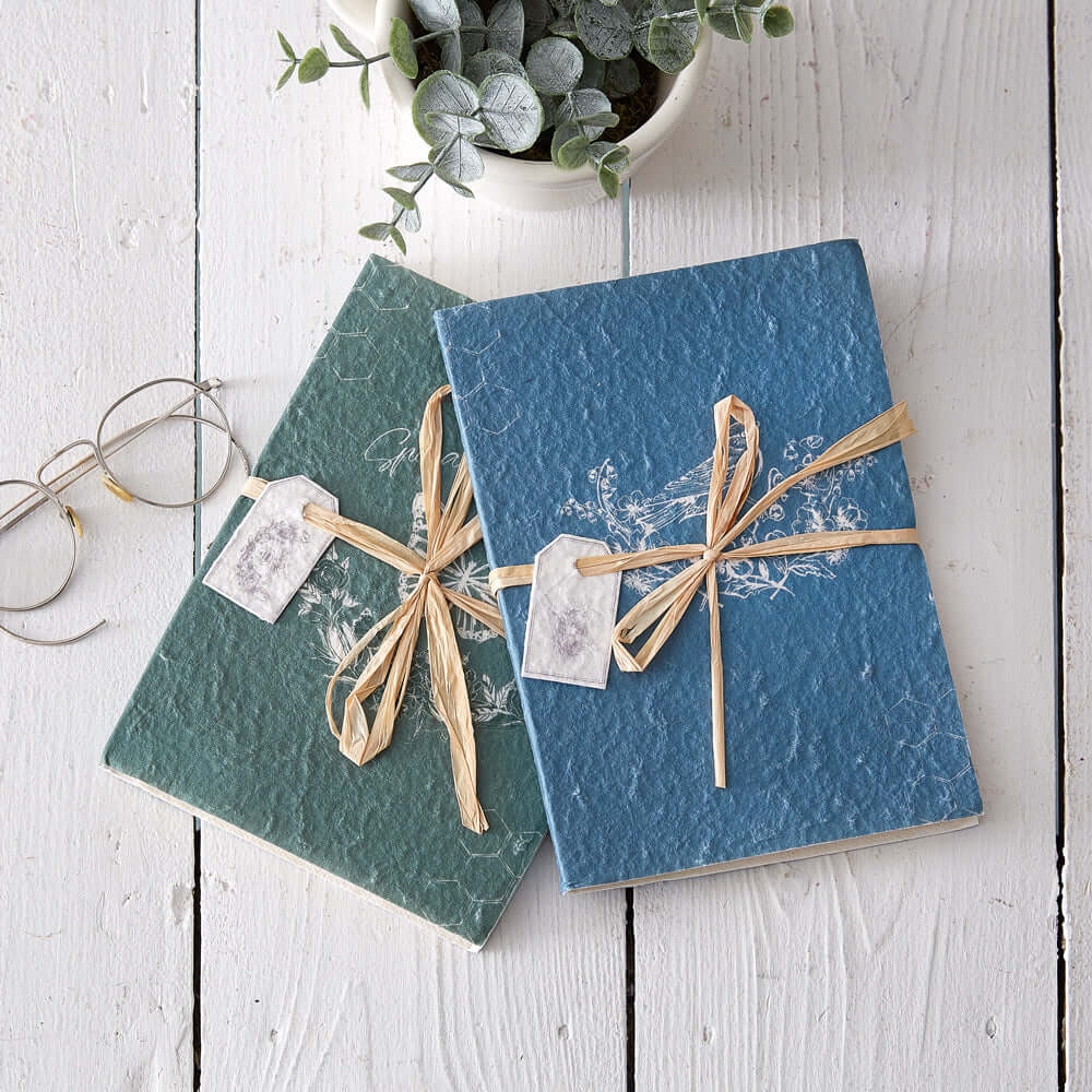 Vintage Cottagecore Handmade Journals (Set of 2) with textured covers on rustic table.