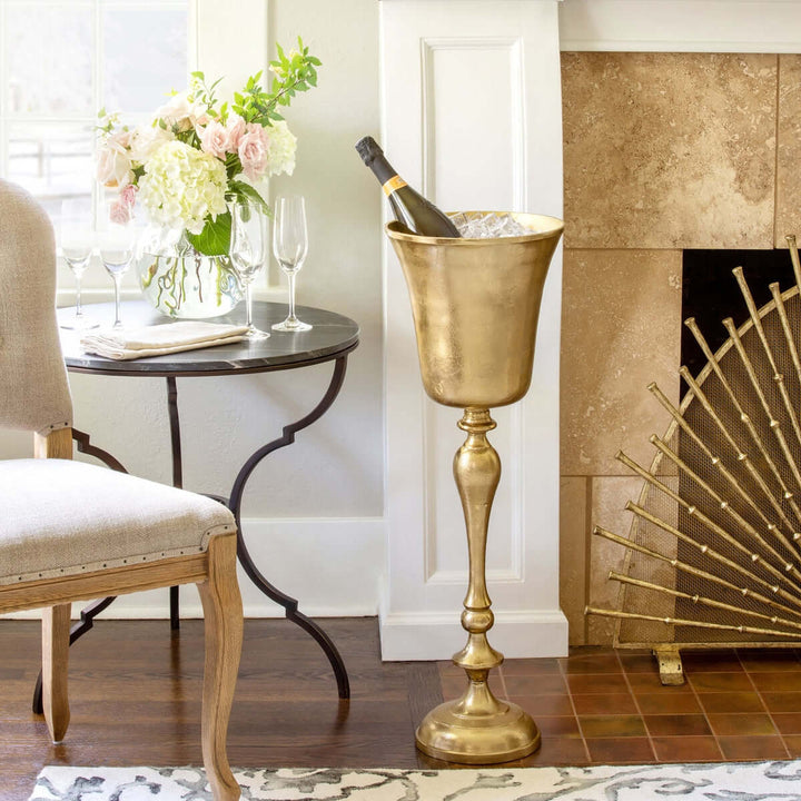Vintage Gold Cast Aluminum Wine Chiller beside a fireplace, showcasing elegant home decor with a classic design.
