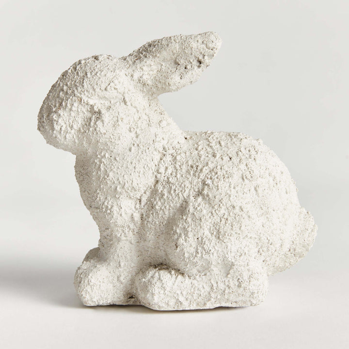 Weathered terracotta bunny statue in aged white finish, perfect for enhancing outdoor garden decor.