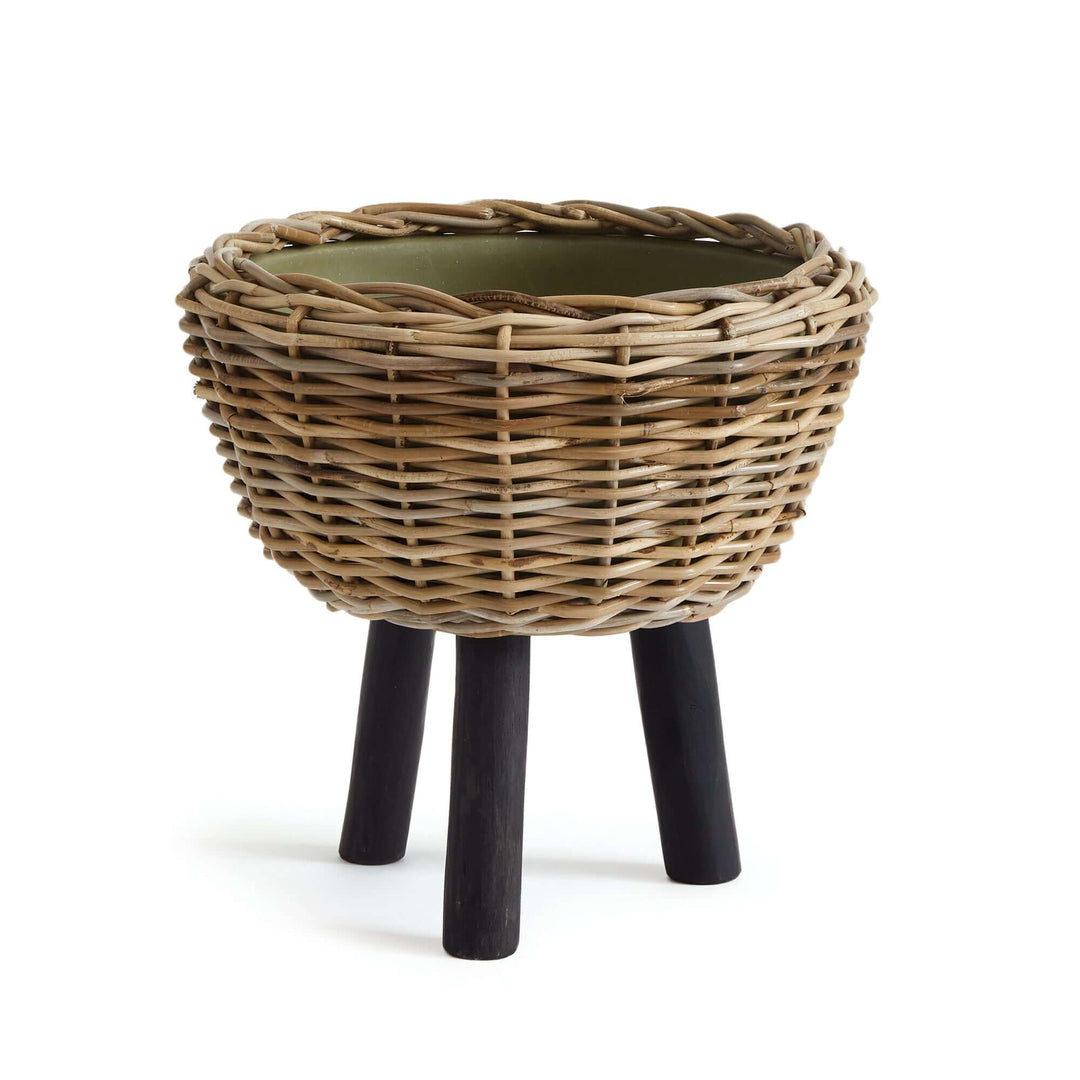 Woven rattan planter with plastic pot and wooden legs, stylish design for indoor greenery.
