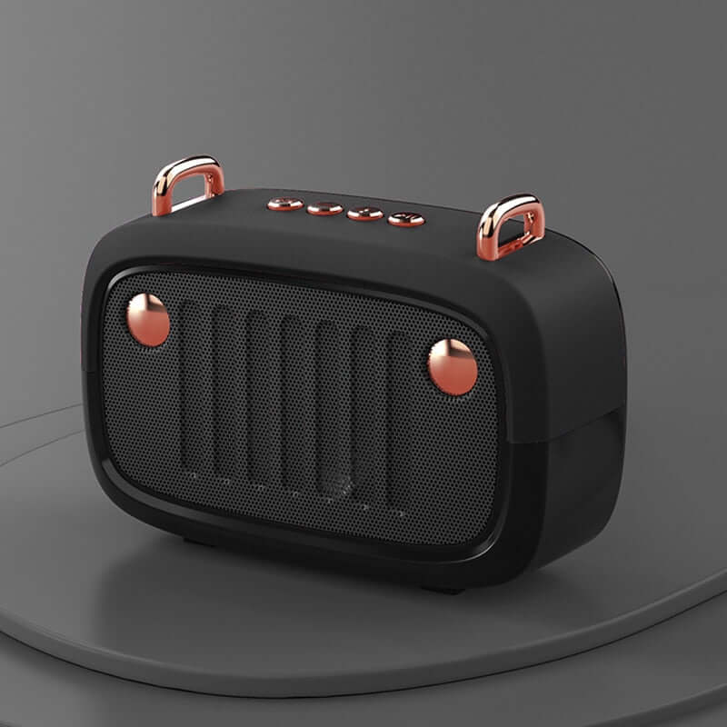 Black portable speaker with rose gold accents on a gray background