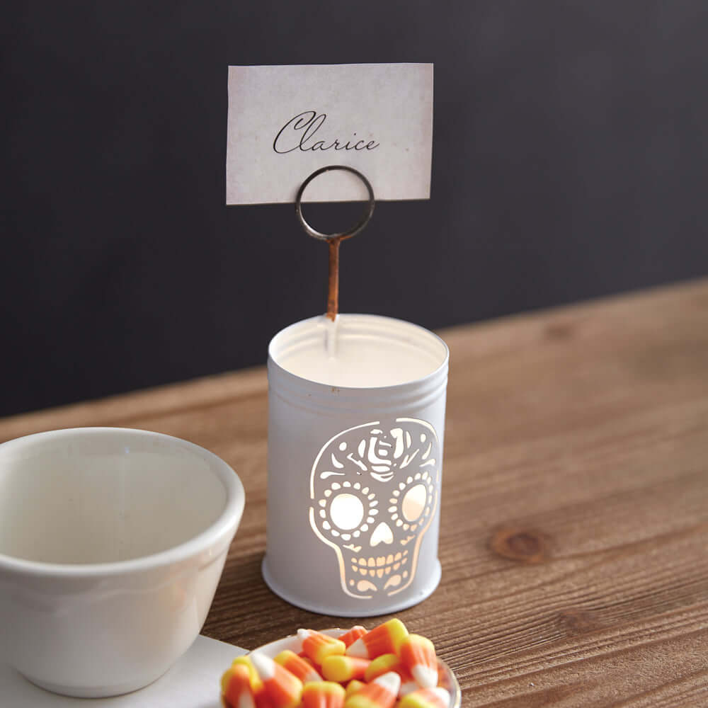 Vintage Sugar Skull Metal Place Card Holder with lit candle, ideal for festive Dia de los Muertos or Halloween gatherings.