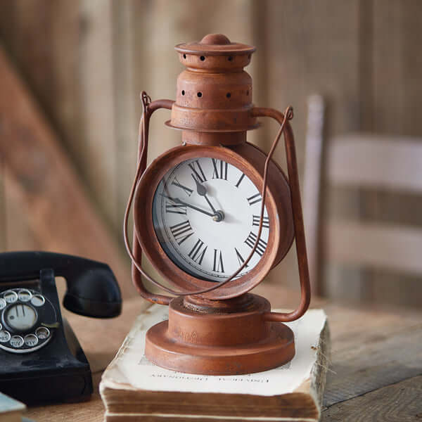 Vintage Farmhouse Lantern Clock with rust-finished metal on a wooden surface, inspired by old homesteads and rural railways.