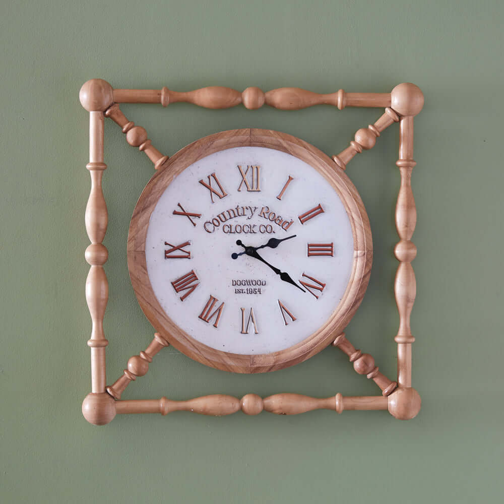 Rustic wooden farmhouse wall clock with vintage country road design and Roman numerals on a green wall background.