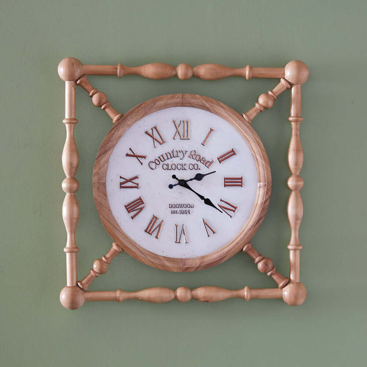 Rustic wooden farmhouse wall clock with vintage country road design and Roman numerals on a green wall background.