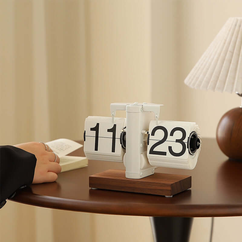 Tabletop flip clock with wooden base on a desk, blurred background