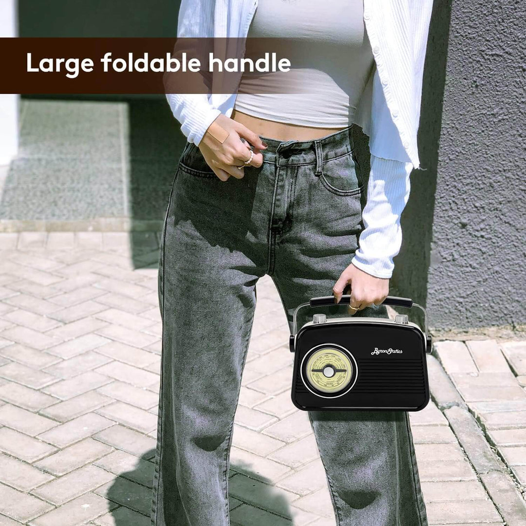 Person holding a vintage-style radio  standing on a paved surface.