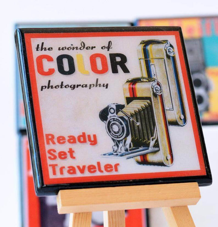 Vintage-style ad on a coaster for 'the wonder of color photography' on a small easel.