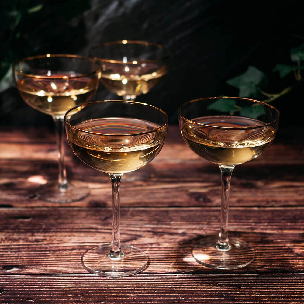Four wine glasses filled with white wine on a wooden table with a dark background