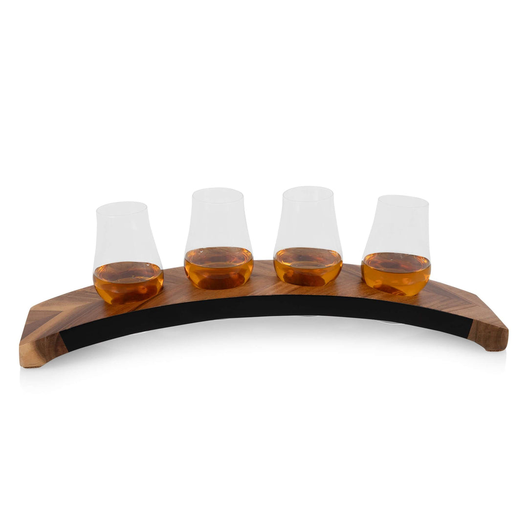Four glass tasting cups with a wooden holder on a white background