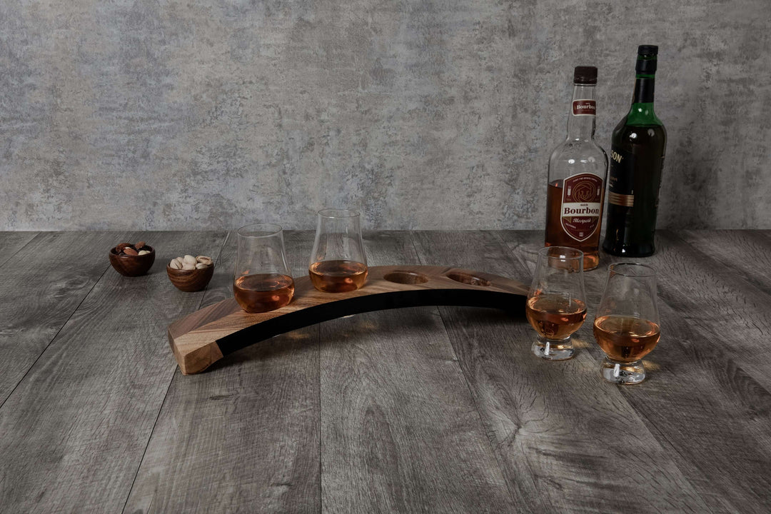 Wooden whiskey tray with glasses and bottles on a wooden surface