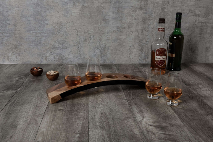 Wooden whiskey tray with glasses and bottles on a wooden surface