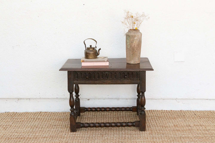 Wooden side table with decorative items against a white wall