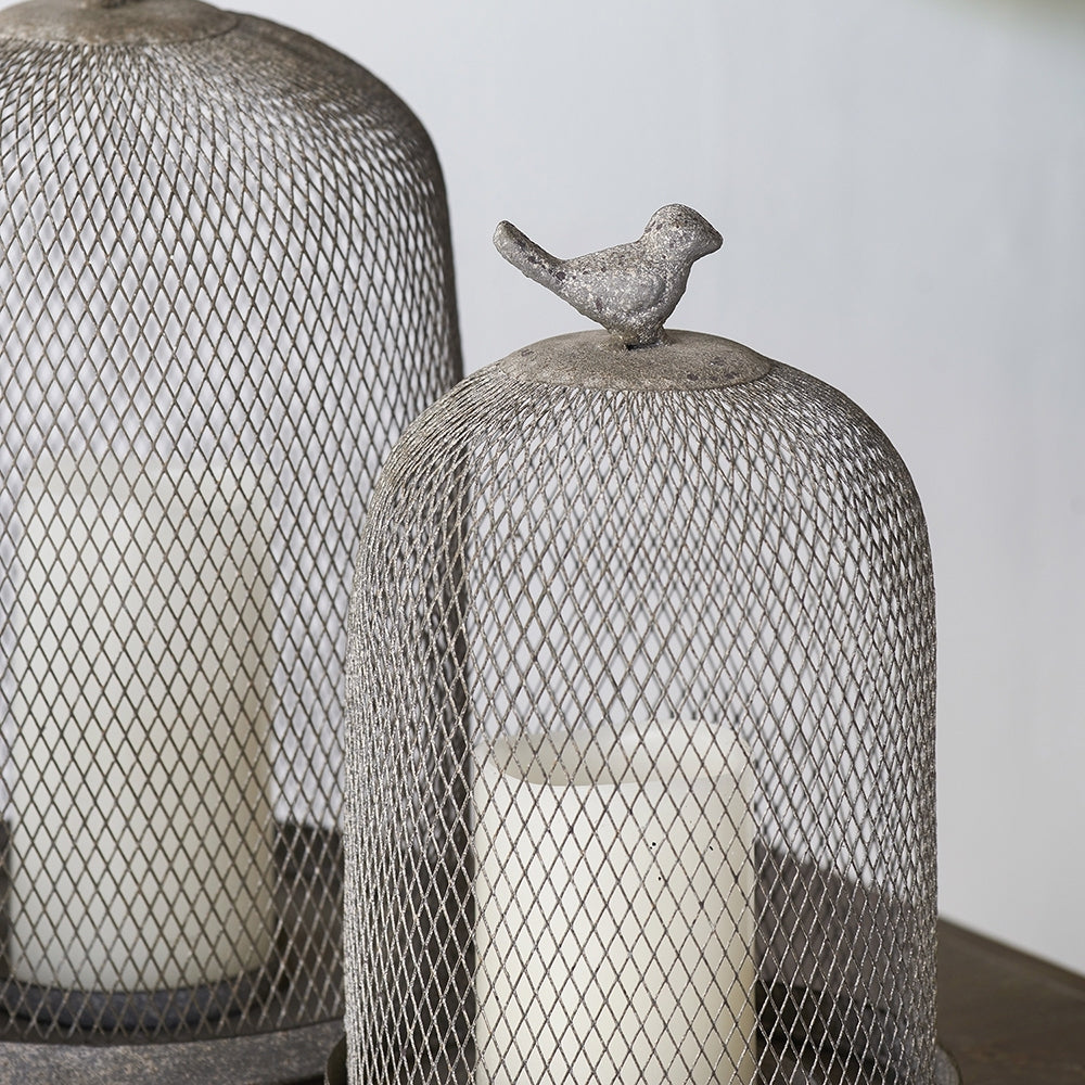 Decorative mesh domes with a bird figurine on top against a neutral background