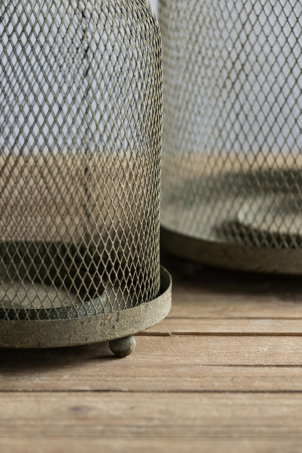 Metal mesh candle holders on a wooden surface