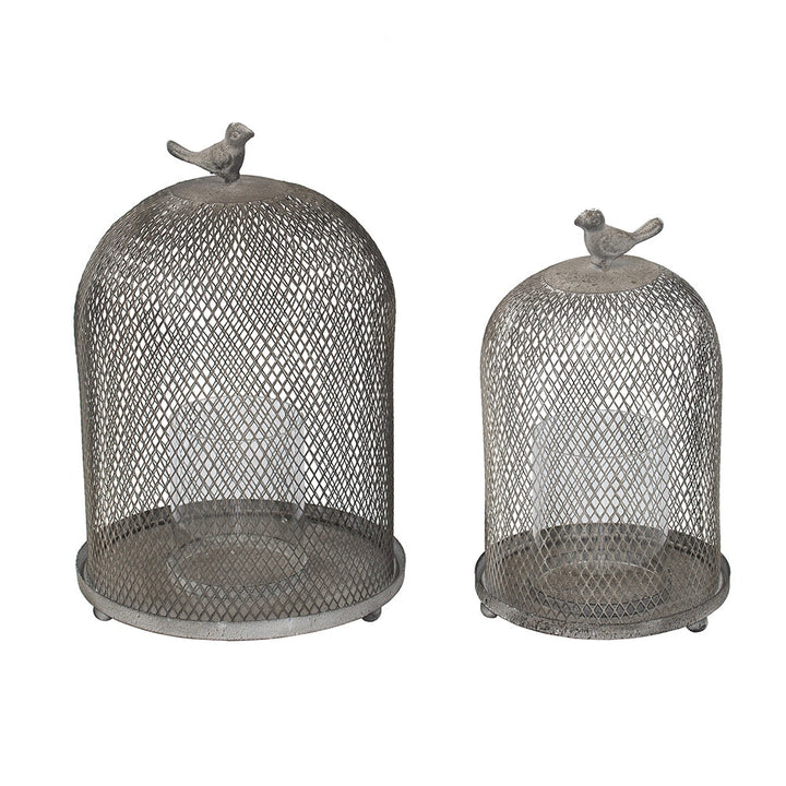 Two metal mesh domes with bird figurines on top on a white background