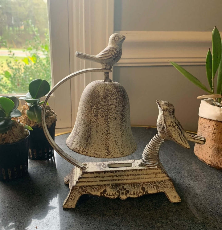 Antique cast iron bird counter bell with whimsical design, featuring two sculpted birds and a charming vintage aesthetic.