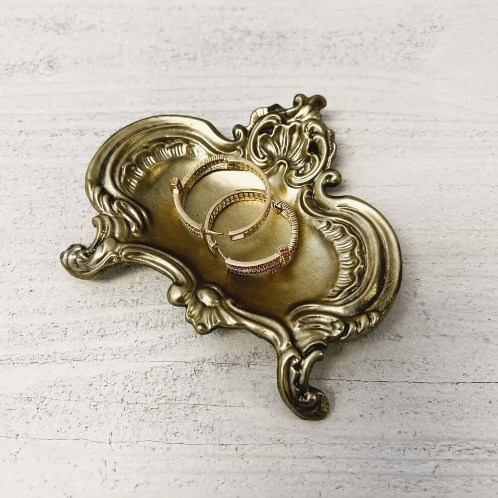 Antique Gold Baroque Jewelry Dish with rings on a table