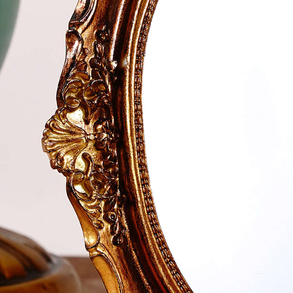 Close-up of an ornate gold mirror frame on a white background