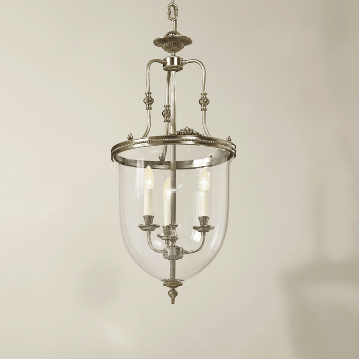 Vintage-style pendant light with clear glass shade on a beige background