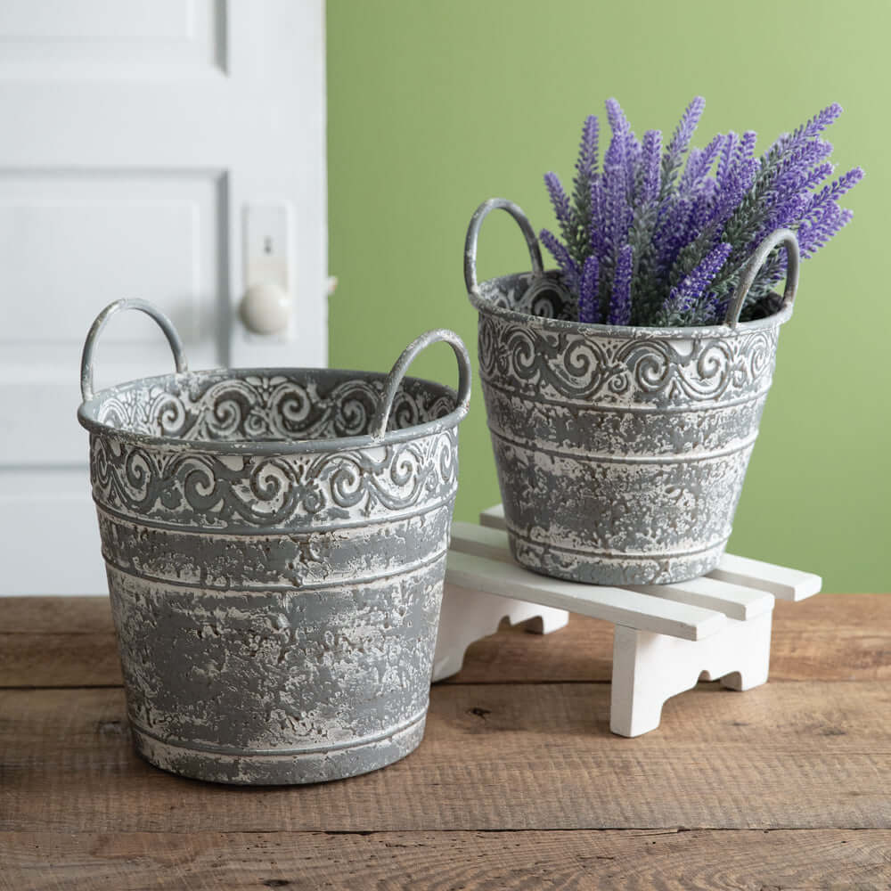 Set of 2 antique metal buckets with intricate filigree, distressed finish, ideal for rustic decor or flower planters.