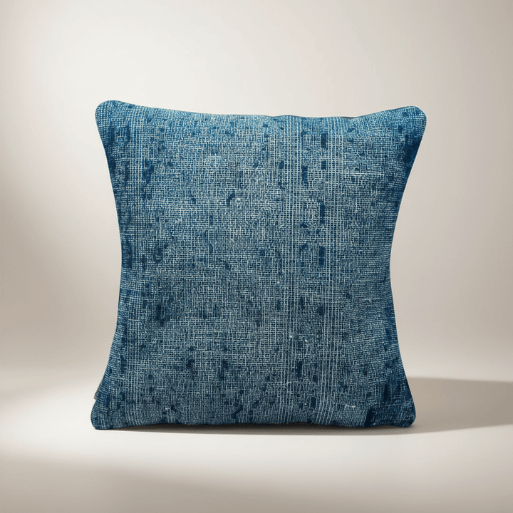 Blue textured pillow on a beige background