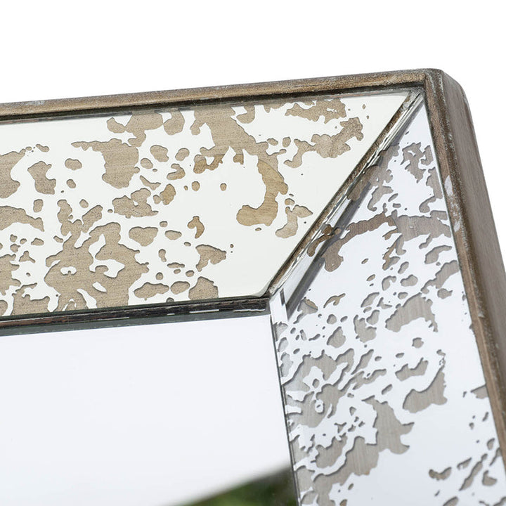 Decorative mirror with a textured frame on a white background
