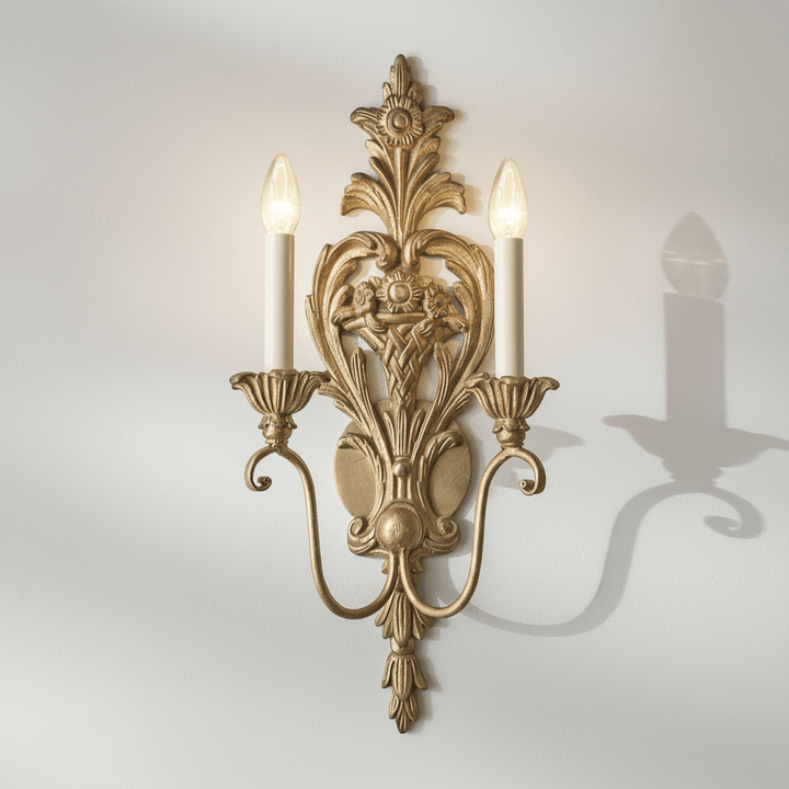 Decorative silver wall sconce with two lit candles on a plain background