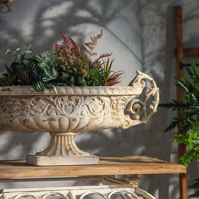 Decorative stone planter with plants on a wooden surface