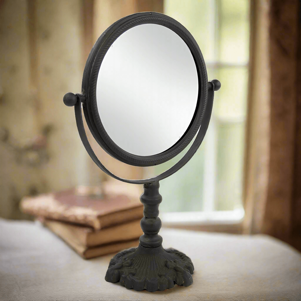Antique swivel tabletop makeup mirror with ornate cast iron frame, perfect for elegant vanity décor.