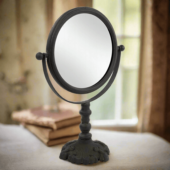 Antique swivel tabletop makeup mirror with ornate cast iron frame, perfect for elegant vanity décor.