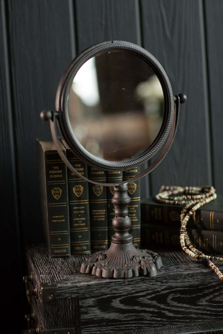 Antique swivel tabletop makeup mirror with ornate cast iron frame, perfect for vintage home décor.