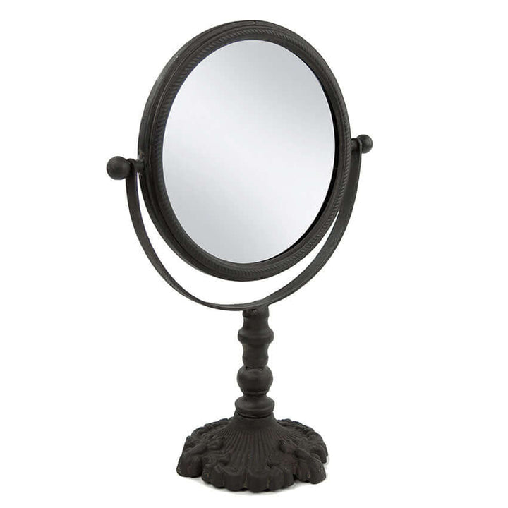 Antique swivel tabletop makeup mirror with ornate cast iron frame, perfect for vintage home decor.