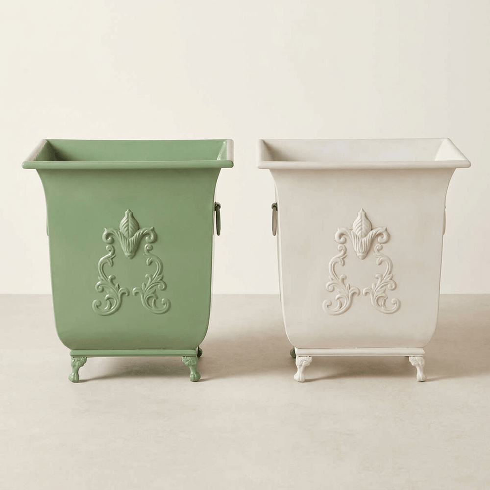 Side-by-side comparison of the Aveline metal planter in Soft Garden Green and Antiqued White; alternative finishes sold separately.
