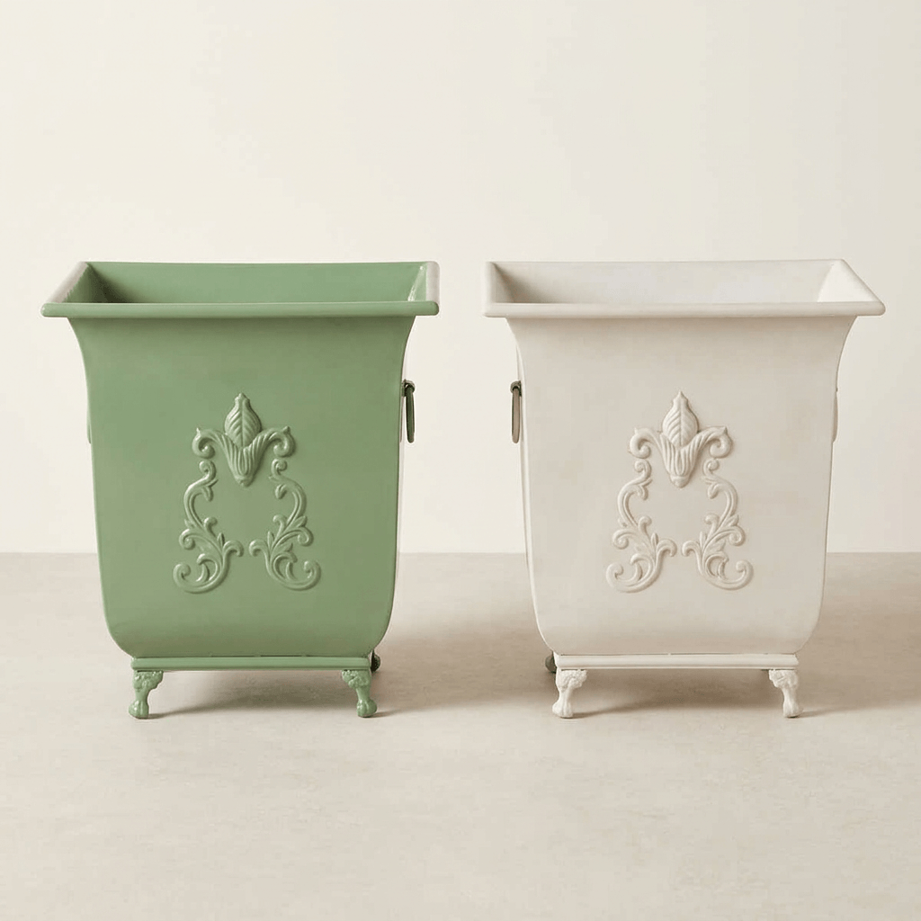 Side-by-side comparison of the Aveline metal planter in Soft Garden Green and Antiqued White; alternative finishes sold separately.