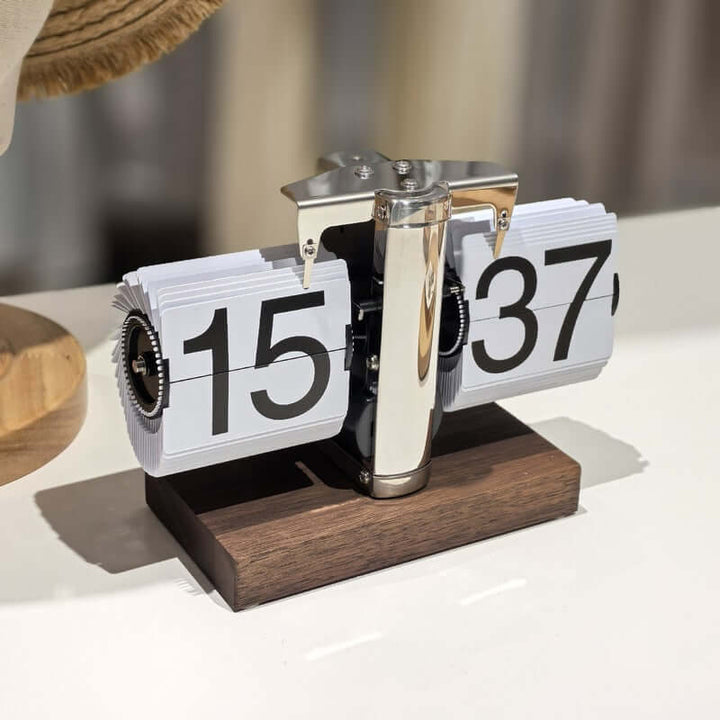 Retro flip clock with wooden base on a neutral background