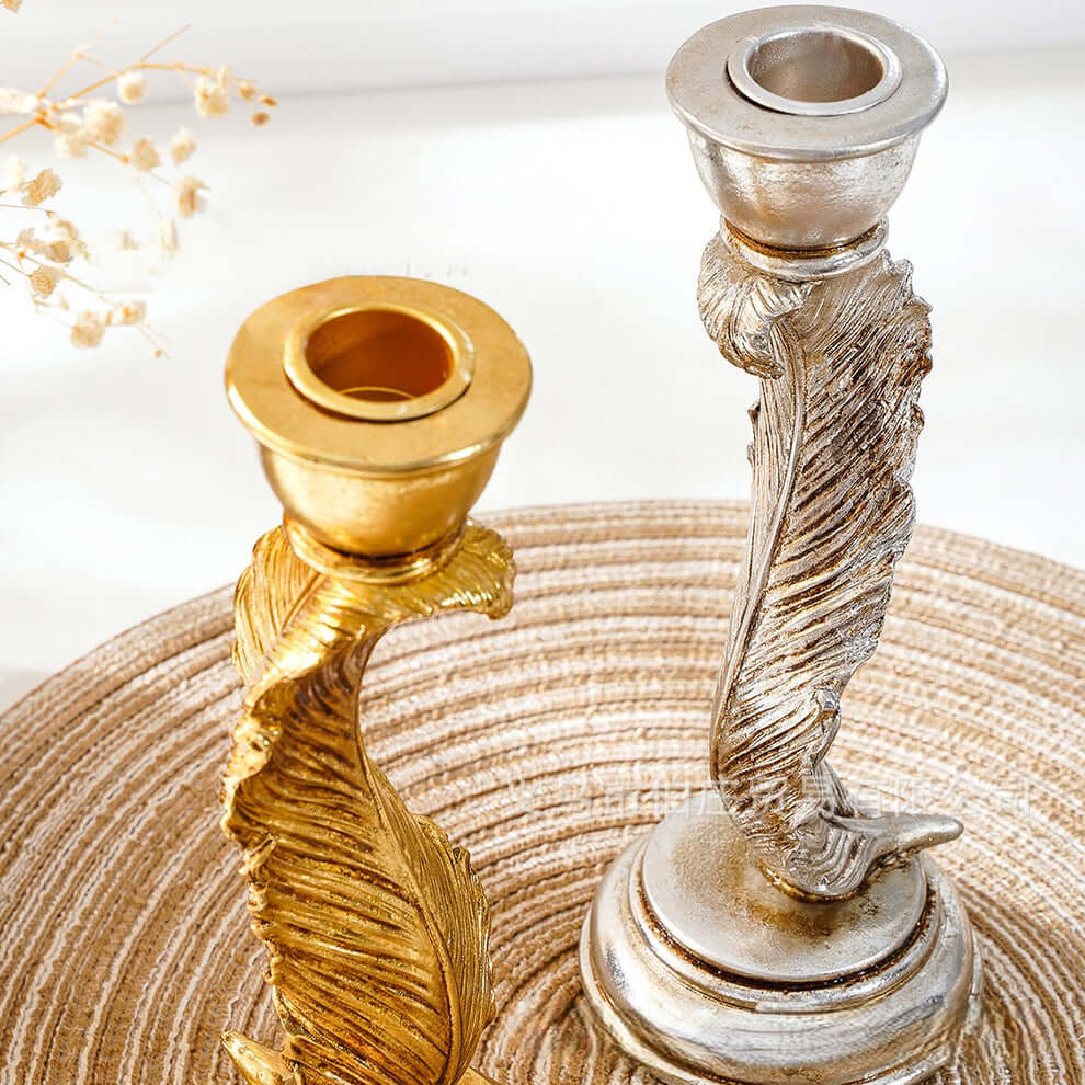 Gold and silver candle holders on a textured surface with a blurred background