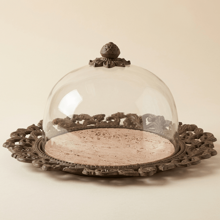 Bellavita marble cake plate with ornate dark acanthus metal border and glass dome on an ivory background