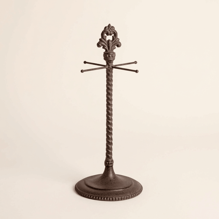 Empty Bellavita measuring cup holder with dark metal twisted stem and fleur-de-lis finial on ivory background