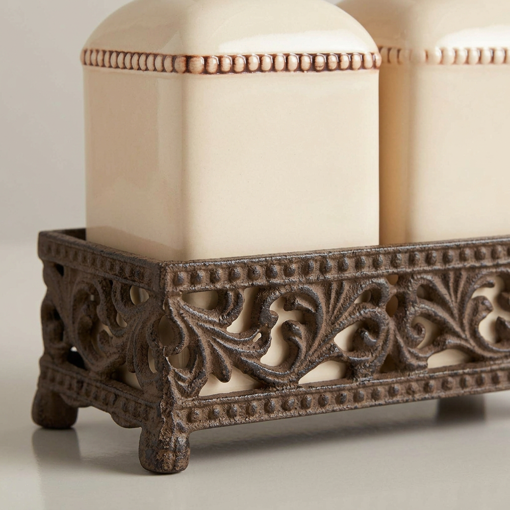 Close-up of cream ceramic dispenser detailing and the ornate acanthus metal holder