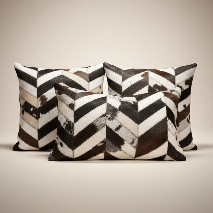 Three decorative pillows with a black and white chevron pattern on a beige background