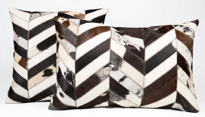 Two decorative pillows with black, white, and brown chevron pattern on a white background