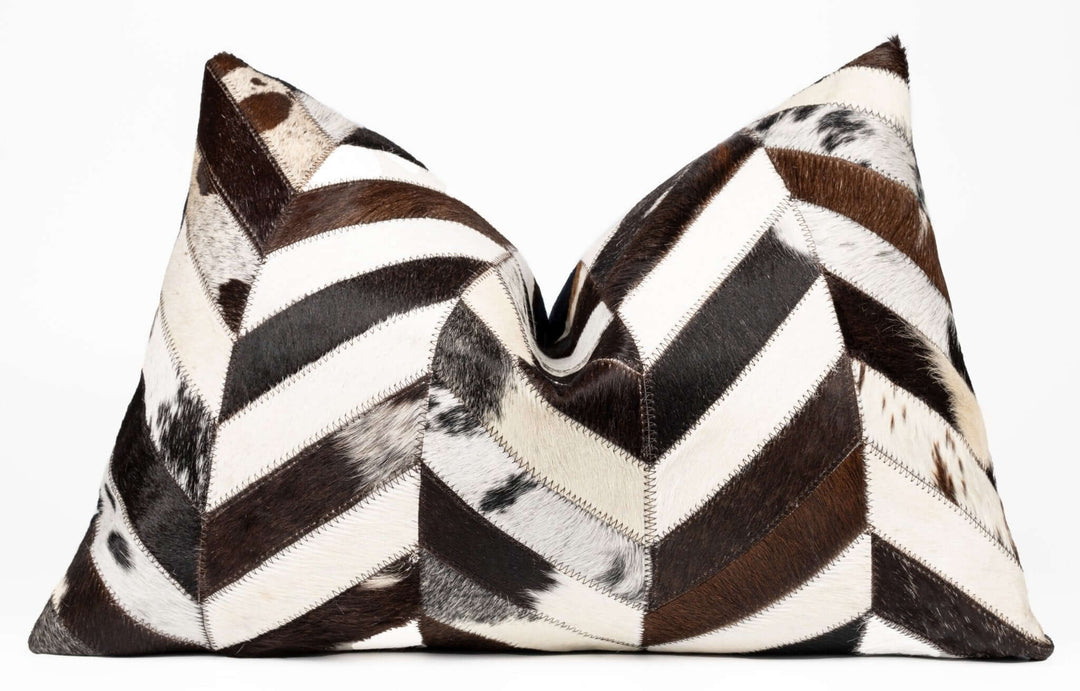 Two decorative pillows with a chevron pattern in brown, black, and white on a white background.