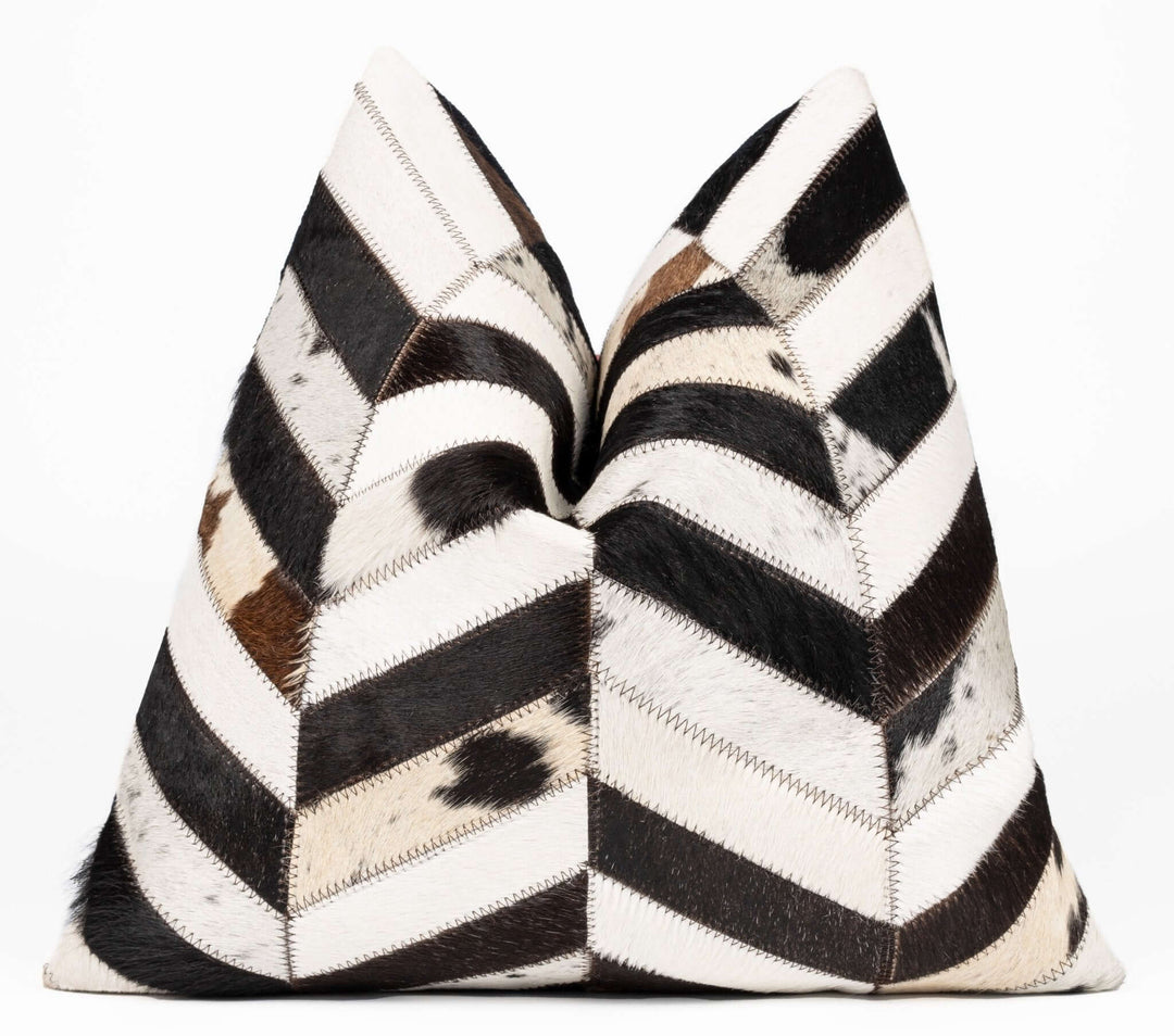 Decorative pillows with black, white, and brown chevron pattern on a white background