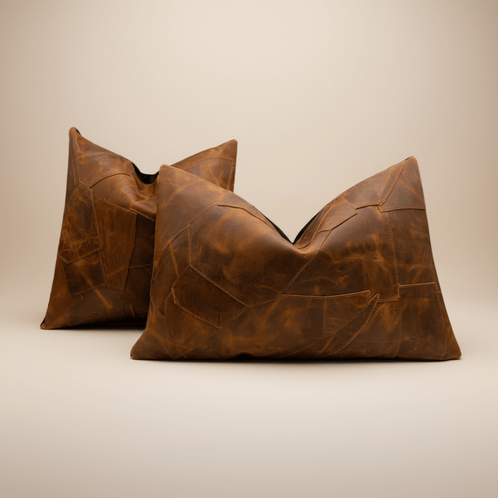 Two brown leather pillows on a beige background