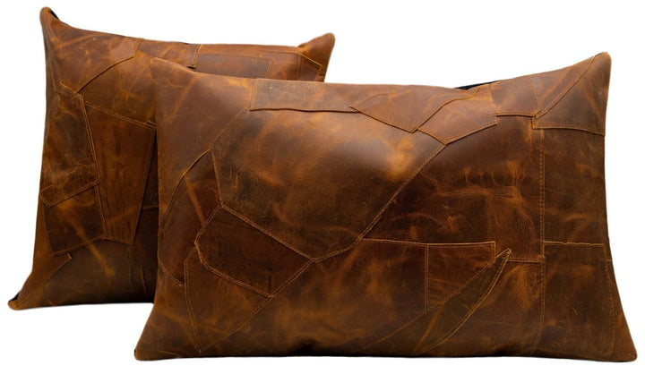 Two brown leather pillows on a white background
